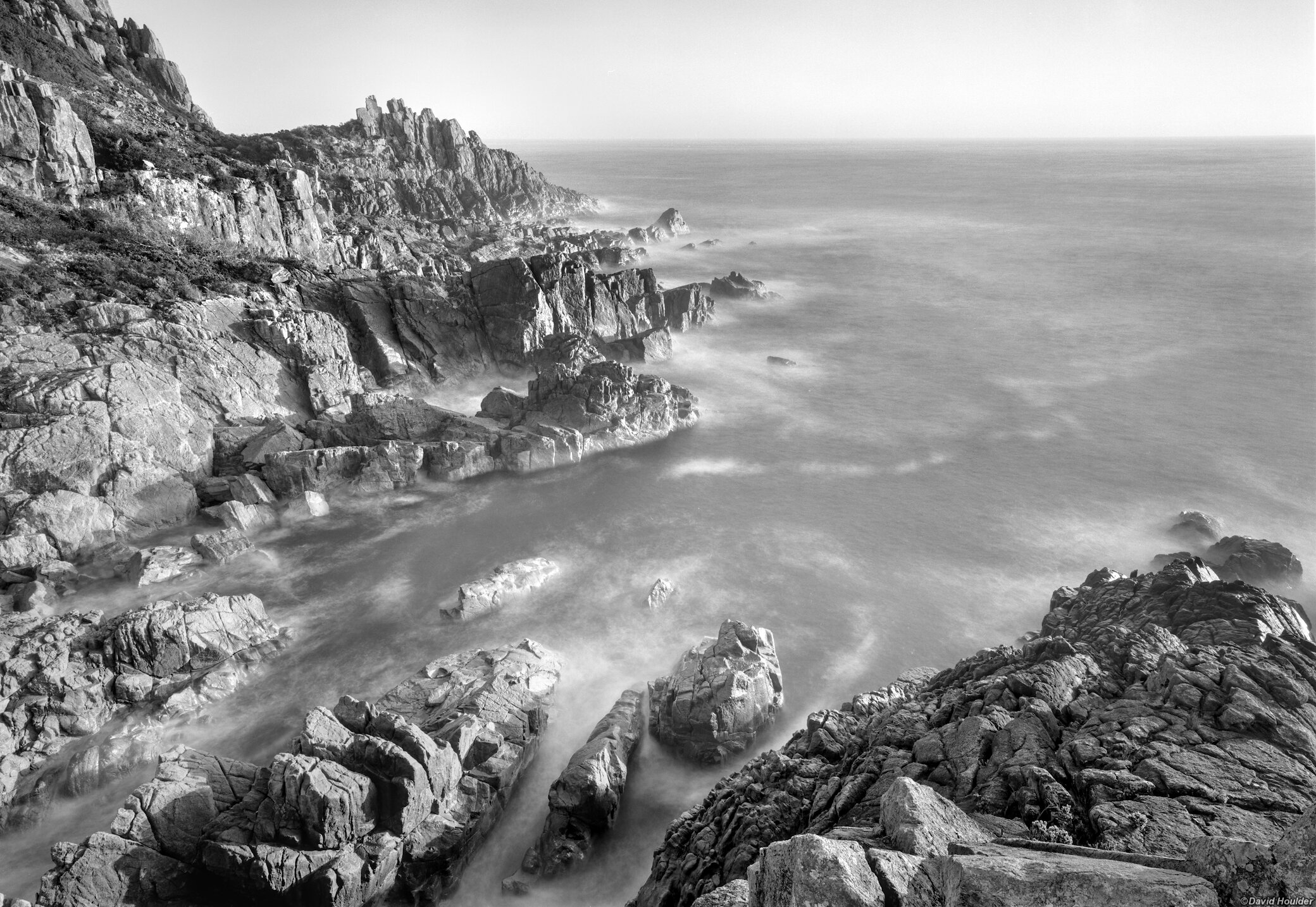 Looking down on a rocky bay, cliffs and the ocean at sunrise