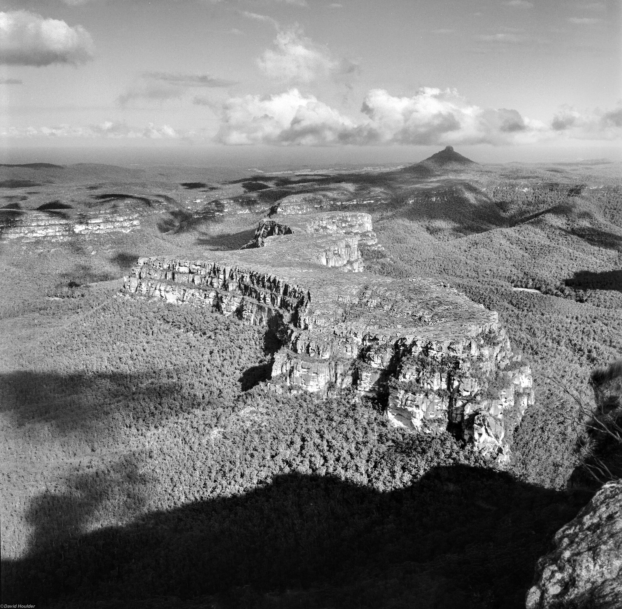 Looking down on a rugged plateau and forest with shadows of clouds