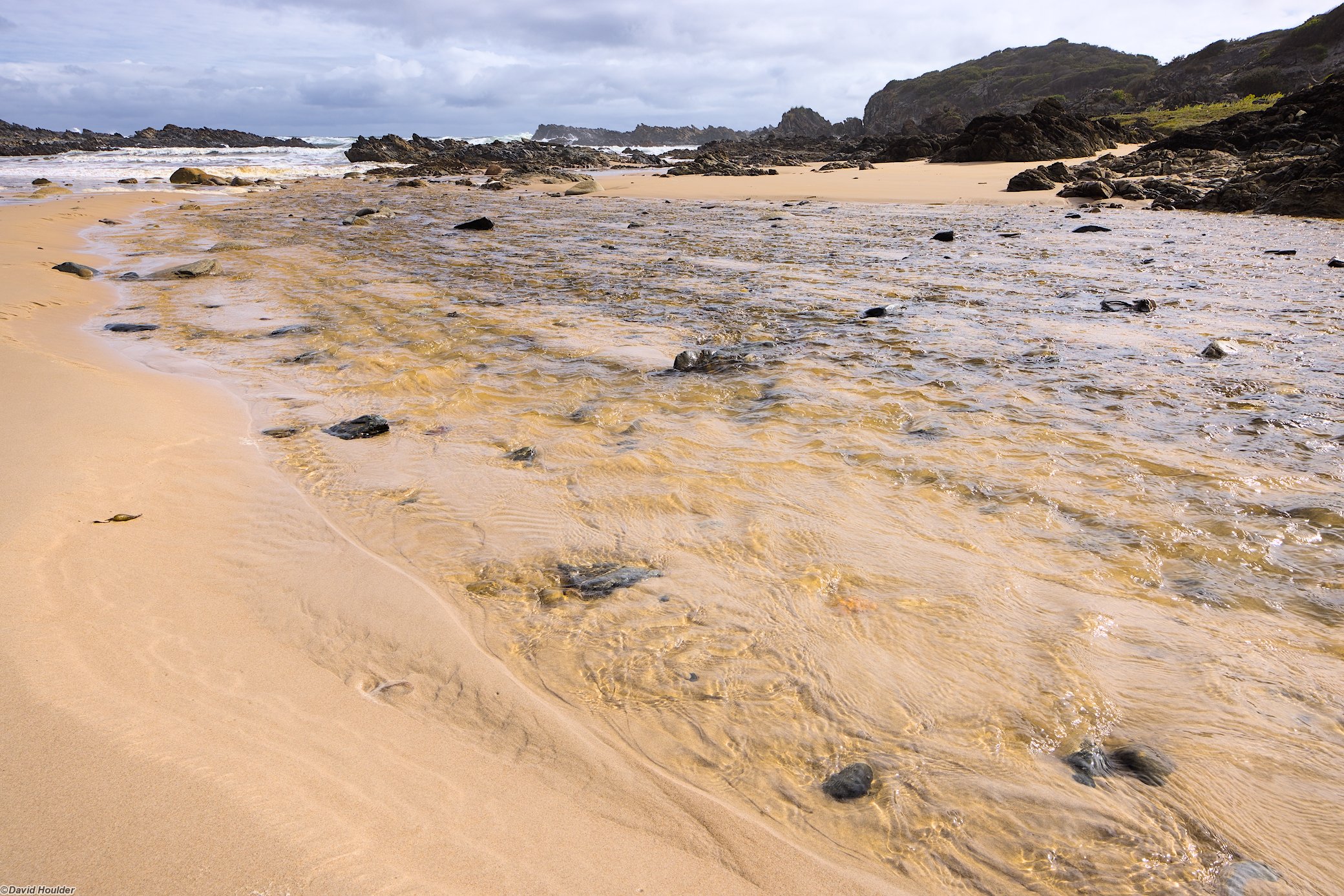 Stream flowing over a beach into the ocean